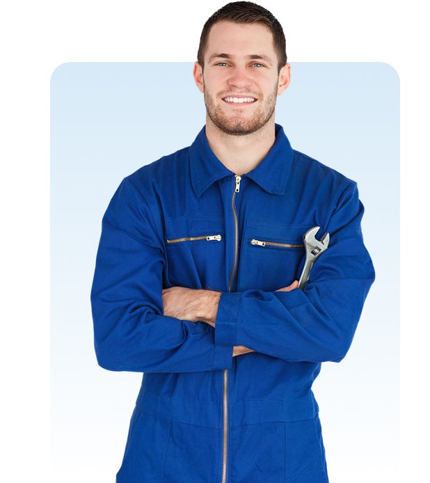 Smiling worker in blue coveralls with wrench.